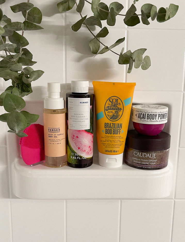 A variety of bath and body essentials in a shower pan.