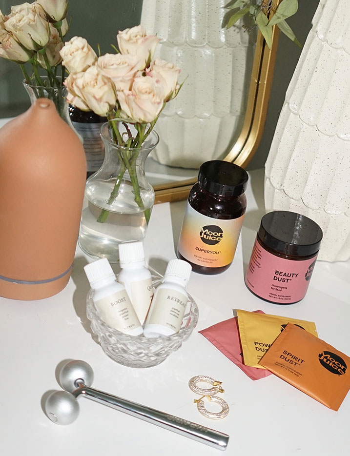 Wellness products like Moon Juice supplements sit on top of a beauty vanity. Shop Wellness.
