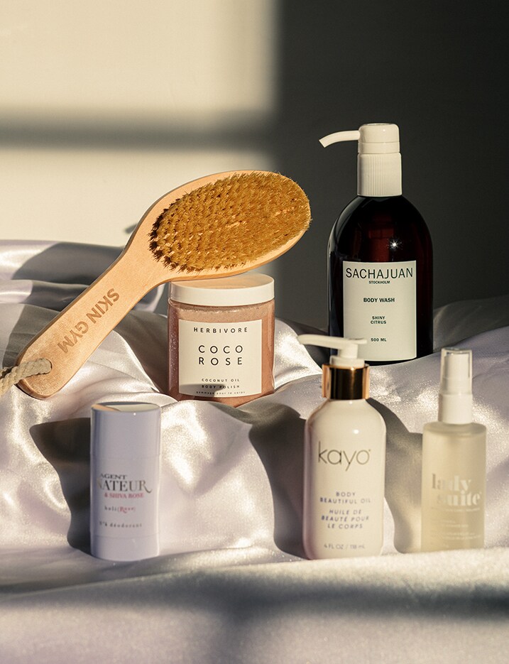 Bath care products displayed on satin sheets.