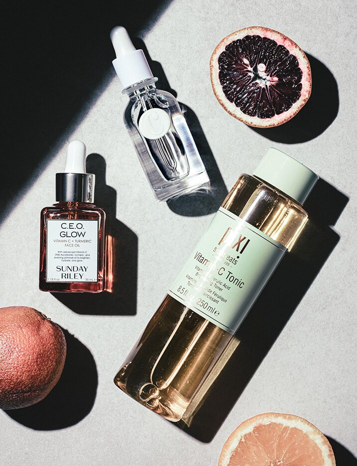 A variety of Vitamin C products laid out on a stone surface. Shop Vitamin C