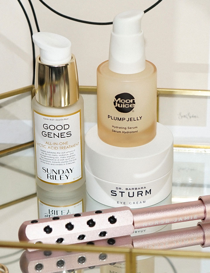 Skincare essentials laid on a glass tray. Shop Indulge Your Skin.