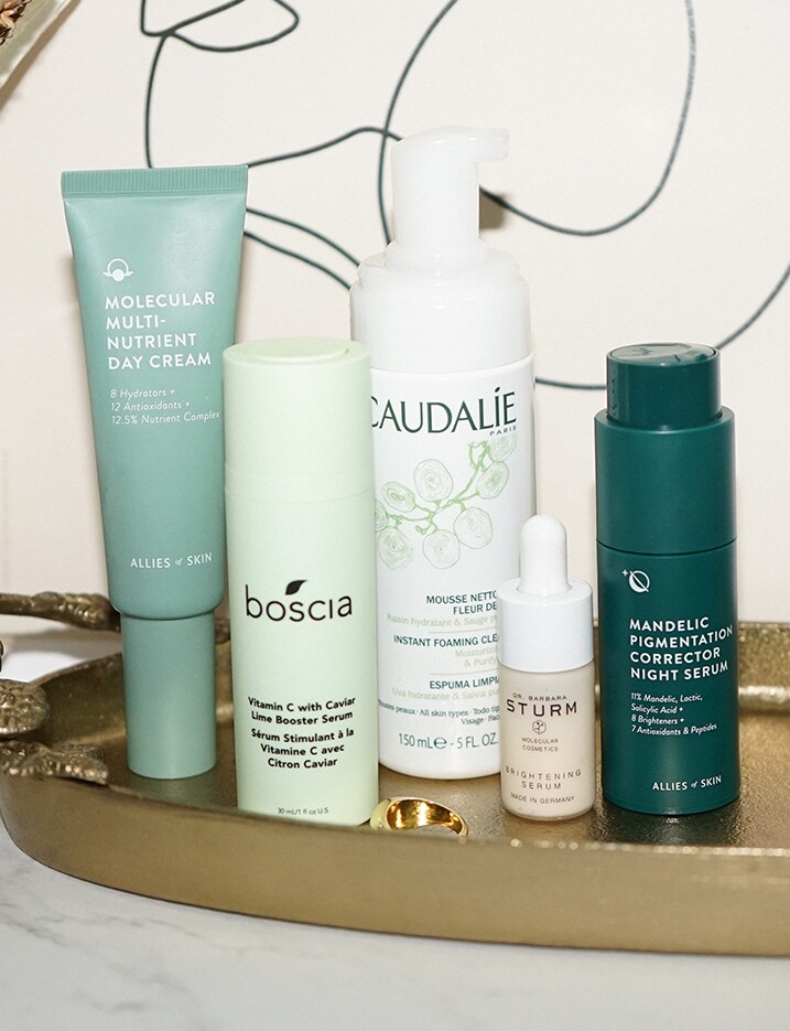 A variety of skincare products sit on a gold tray. Shop Skincare.