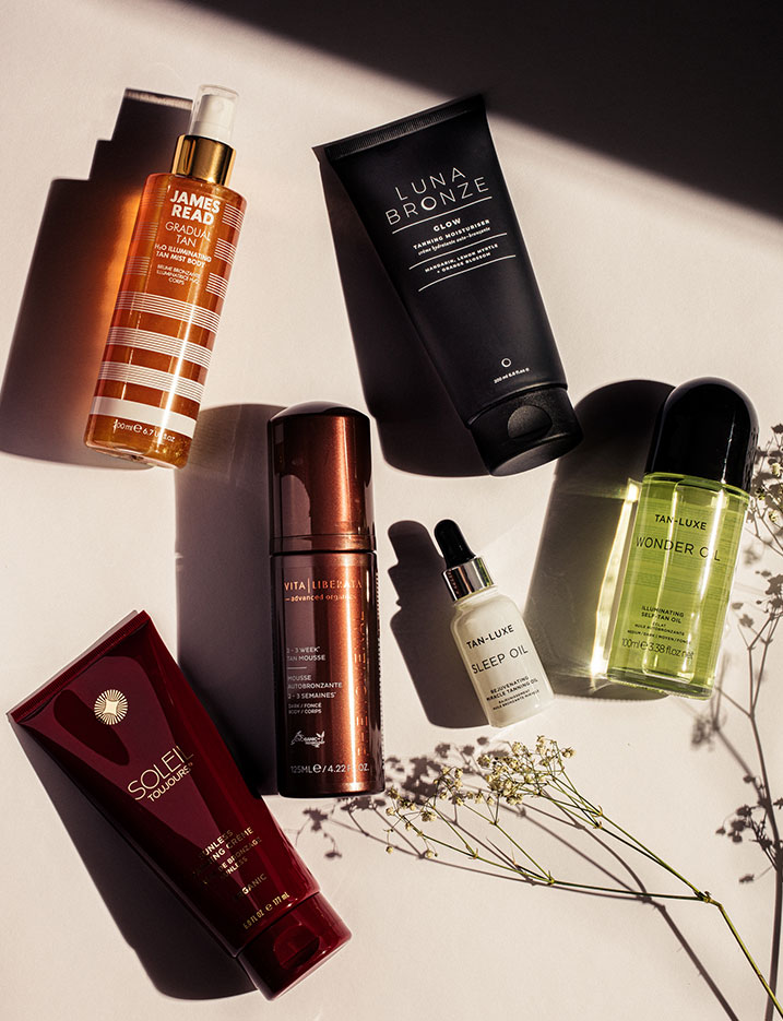 Variety of self-tanning skincare products lay on a tabletop. Shop Self-Tanning