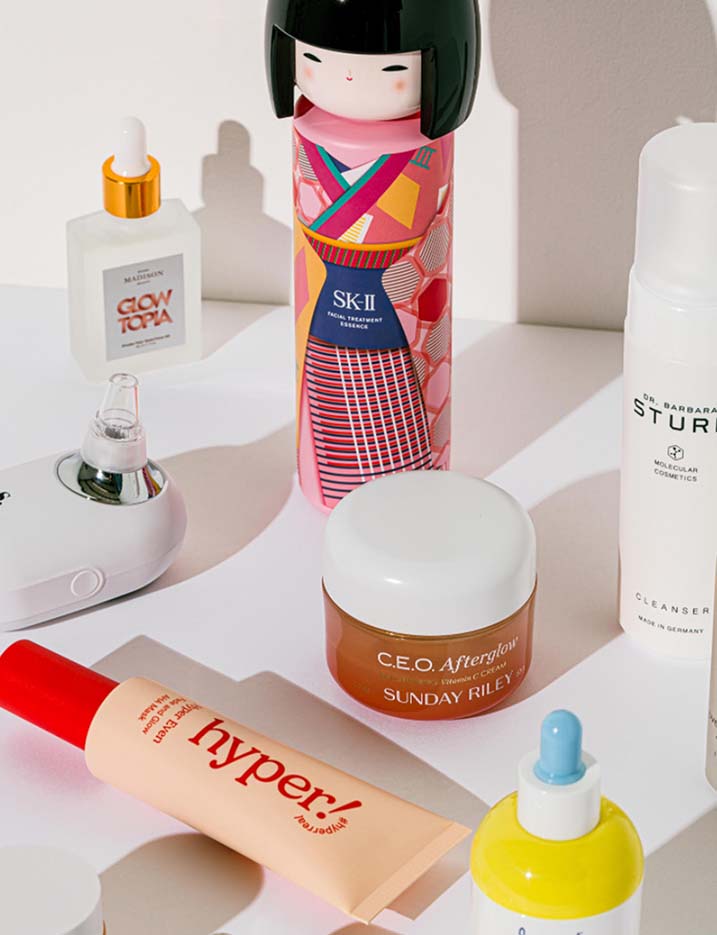 Variety of skincare products and devices on a white tabletop.