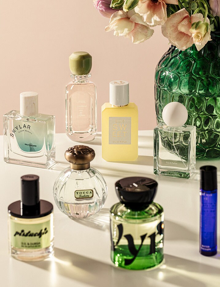 Variety of perfume bottles cast shadows on a table.