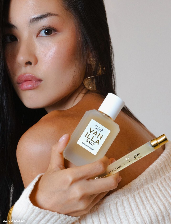 Model holding ELLIS Vanilla Salt perfumes in various sizes.