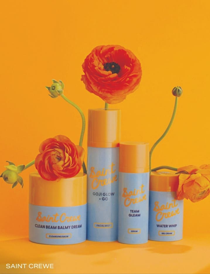 Variety of Saint Crewe skincare surrounded by flowers.