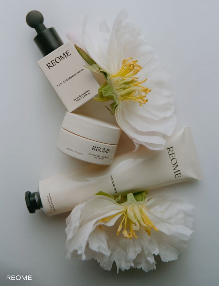 Variety of Reome skincare products placed with flowers.