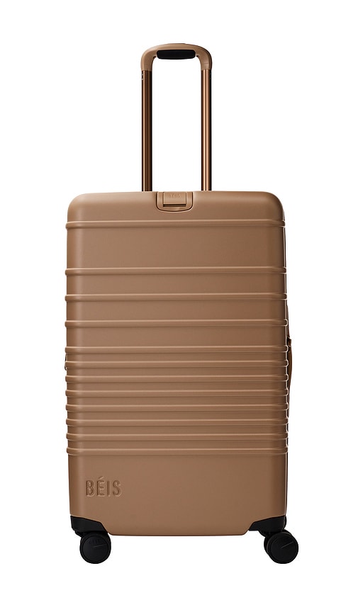The Medium Check-in Roller Luggage in Tan.