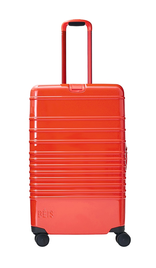 The Medium Check-in Roller Luggage in Red.