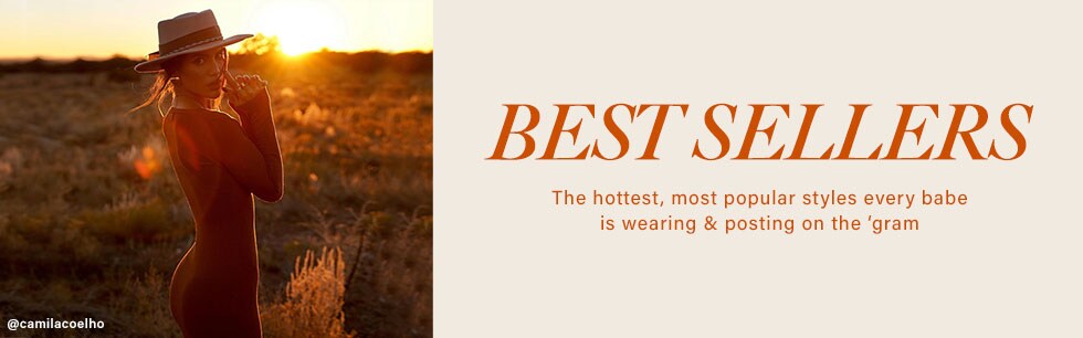 Camila Coelho standing in an open field wearing a brown long sleeve, sweater maxi dress, with a beige hat and brown boots. Shop Best Sellers.