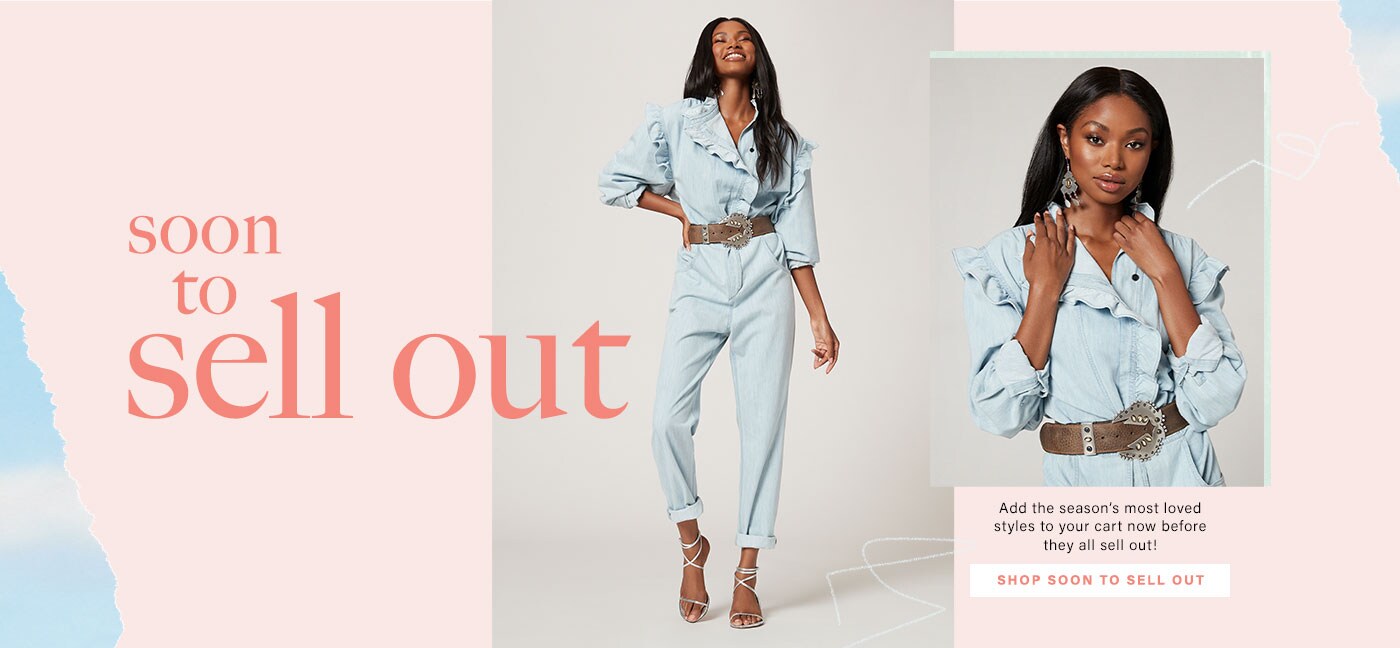A model standing wearing a blue chambray jumpsuit with a ruffle collar and brown belt. Soon to Sell Out. Shop Now.