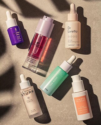 A display of beauty products arranged with a shadow background. The Beauty Shop. Shop Now.