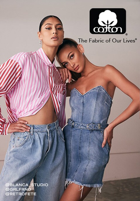 Two models pose as they lean on each other; the one on the left wears a pink and white striped butto