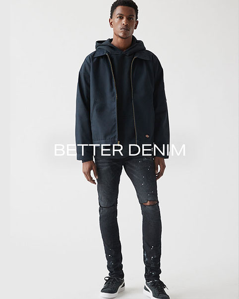 On the left, a cropped image of model’s lower body, focusing on his legs. He is wearing a blue dickie’s workwear jacket with a black hooded sweatshirt and black jeans with rips at the knees and black and white Puma sneakers. The image on the right is a full body image of the same look. Better Denim. Sturdy yet comfortable, these are the denim styles you need to invest in for 2022. SHOP DENIM