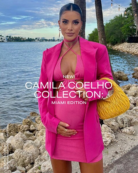 A photo of Camila Coelho wearing a neon pink mini dress that features a halter criss cross in the front and two side cut-outs. She is wearing it with an oversized neon pink blazer and holding a yellow handbag. A photo of Vale Genta and Luana Barron. Vale Genta is wearing a matching set in neon yellow that features a bra top with a silver ring in the middle and a mini skirt that has the same ring off to the side of the top of the skirt. Luana Barron is wearing a sequined yellow strapless midi dress that features defined cups with a cutout in the center and a high asymmetrical slit on one side. Another photo of Camila Coelho wearing the same neon pink outfit from the first photo. Two photos of Camila Coelho wearing a neon green bikini that features a top with a single crossover strap and two waist straps that create a cutout effect on the sides of the bikini top. The top also has two silver rings connecting the straps to the cups of the bathing suit and there is a cutout in the center. The bottoms have silver rings on either side of them. She has it paired with a pastel green and white gingham overshirt worn open and a straw bucket hat. A photo of Racquel Natasha wearing a white matching set that features a cropped tank top and a mid-rise maxi skirt that has a very high slit on one side. Another photo of Vale Genta wearing the matching set in neon yellow. Another photo of Luana Barron wearing the sequined yellow strapless midi dress and Camila Coelho wearing the neon pink mini dress and blazer. New Camila Coelho Collection: Miami Edition. Shop the Collection.
