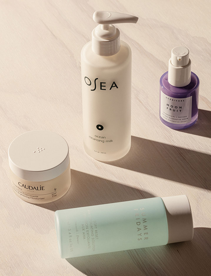 Skincare products from Osea, Caudalie, Herbivore Botanicals and Summer Fridays sit on a marble surface.