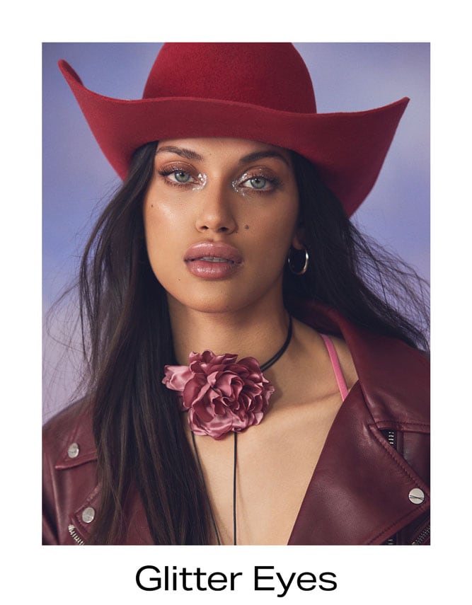 Model with green eyes and complimentary deep warm eyeshadow embellished with metallic glitter.