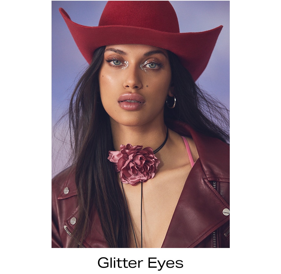 Model with green eyes and complimentary deep warm eyeshadow embellished with metallic glitter.