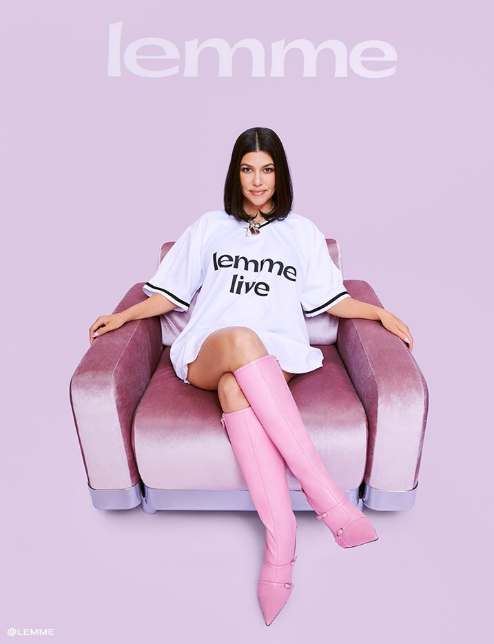 Model sitting on a couch in a white Lemme T-shirt and pink knee-high boots.