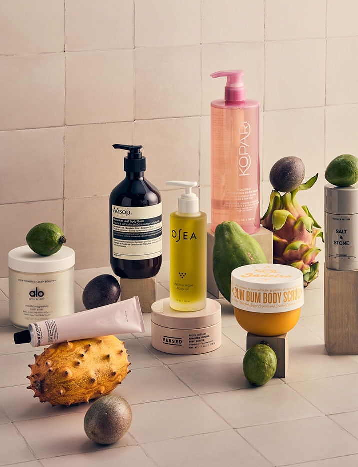 Variety of bath and body products alongside fruits.