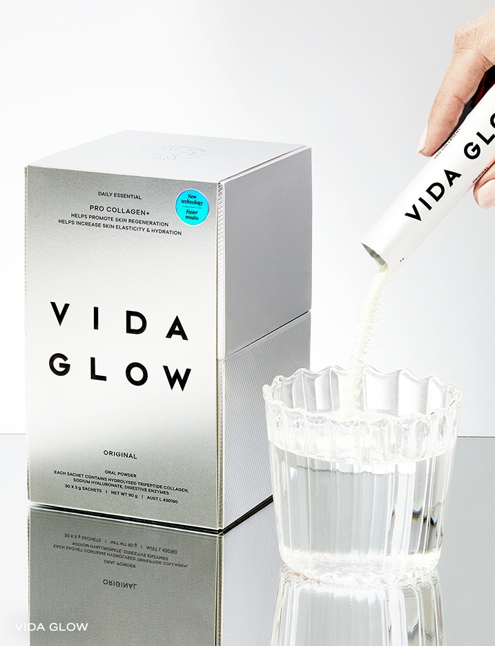 Vida Glow Pro Collagen+ Oral Powder being poured into a glass of water.