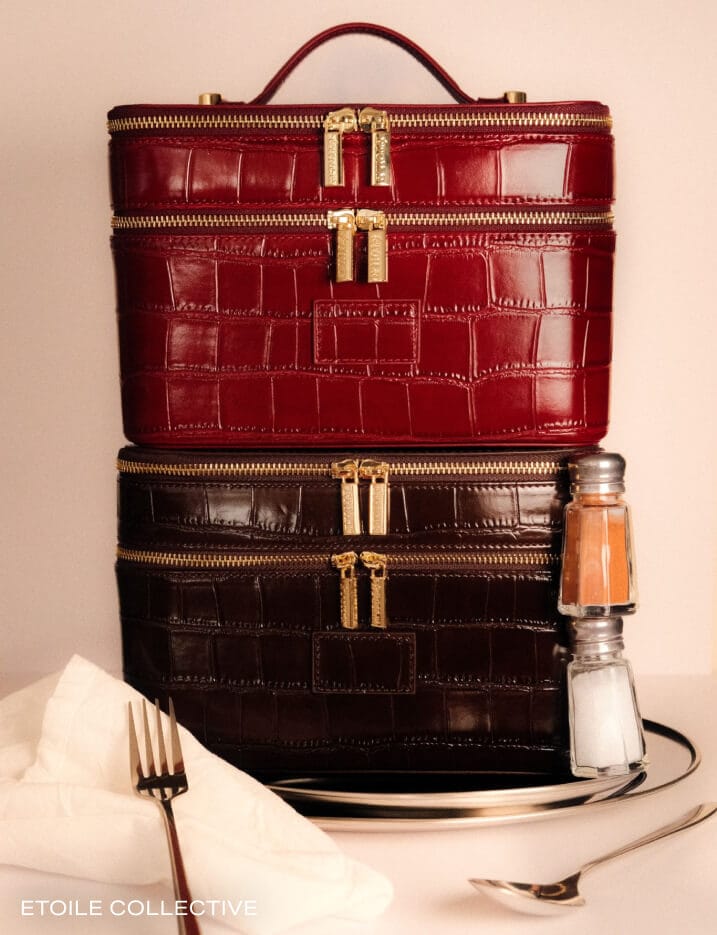 Two leather makeup bags stacked on top of each other.