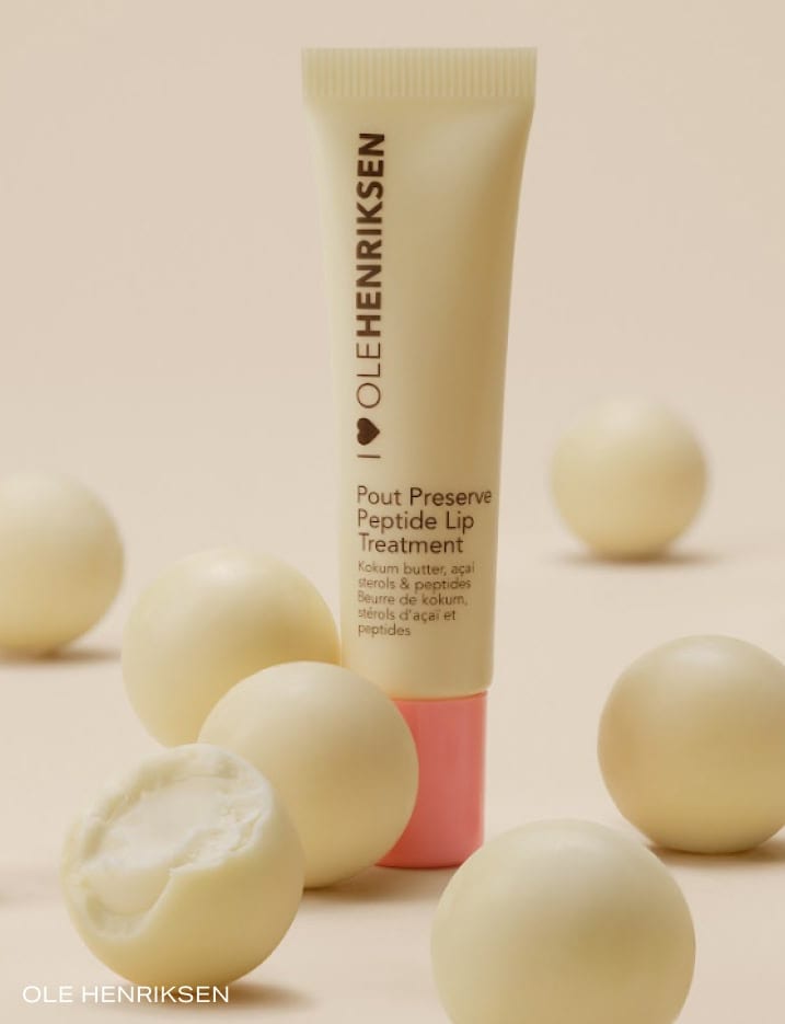 One container of Ole Henriksen Pout Preserve Peptide Lip treatment surrounded by vanilla bon bon.
