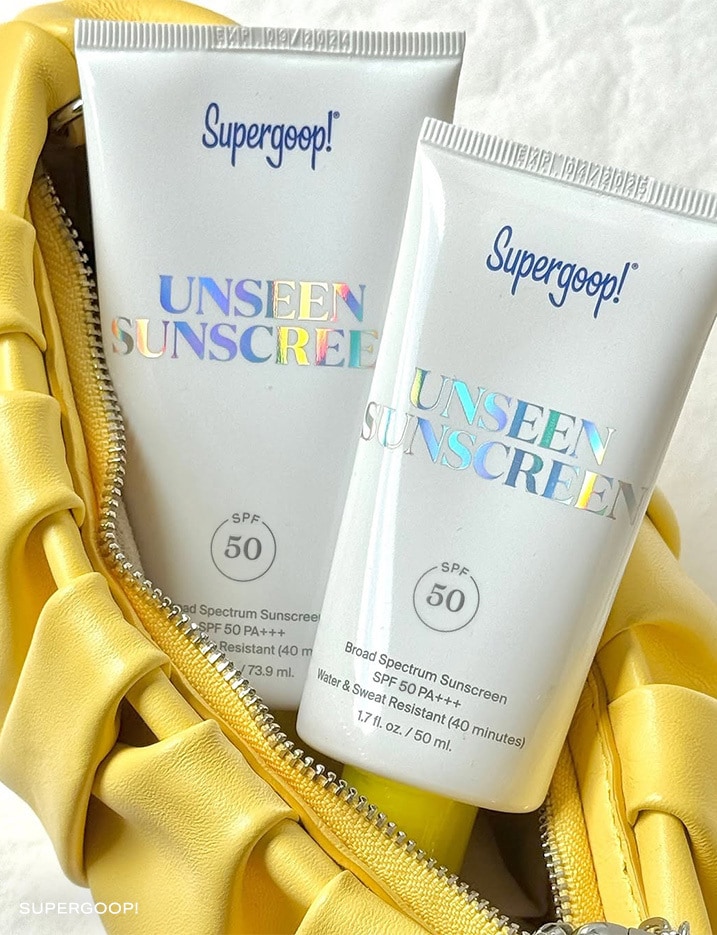 Two tubes of Supergoop Unseen Sunscreen in a opened makeup bag.