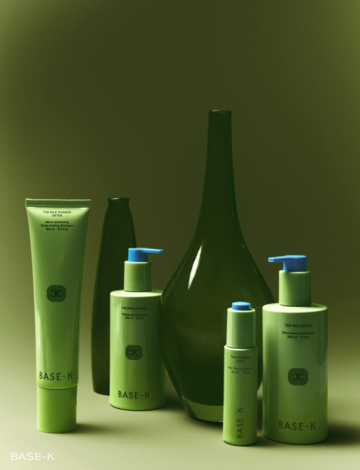 Green bottles of Base-K brand hair products.