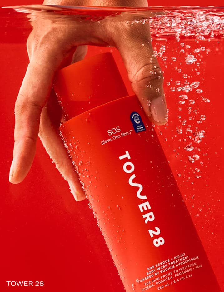 Hand grabbing the Tower28 Body Wash & Treatment under water.