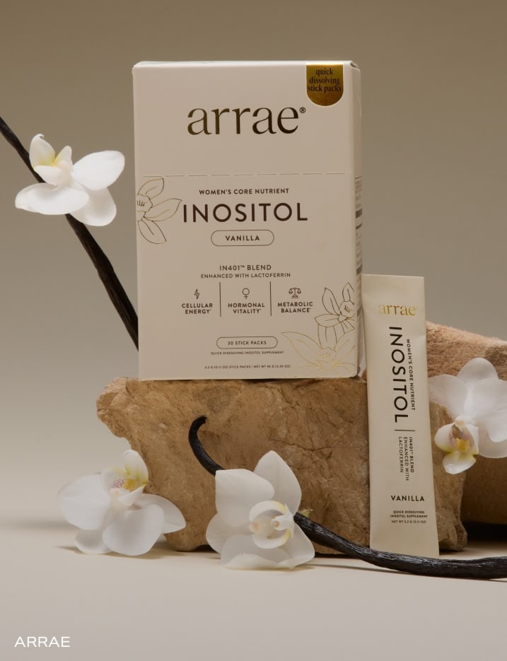 Arrae Women's Core Nutrient Inositol in vanilla flavor on a rock with vanilla bean pods and flowers.