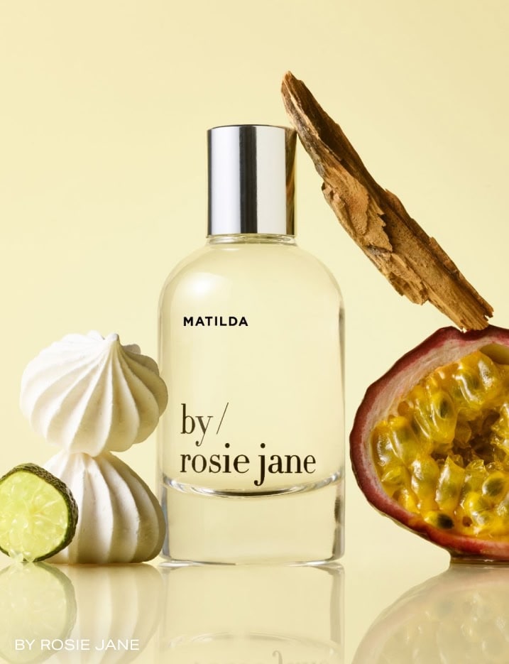 A bottle of By Rosie Jane perfume in Matilda surrounded by fruits and meringue.