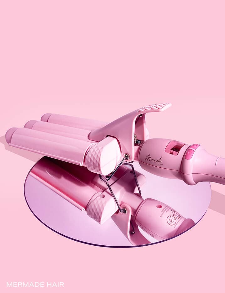 Baby pink Mermade Hair Waver placed on top of a circular mirror.