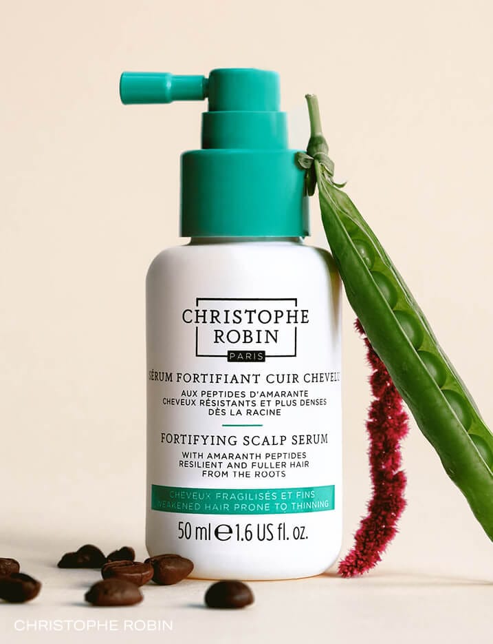 Christophe Robin scalp serum surrounded by coffee beans and peas.